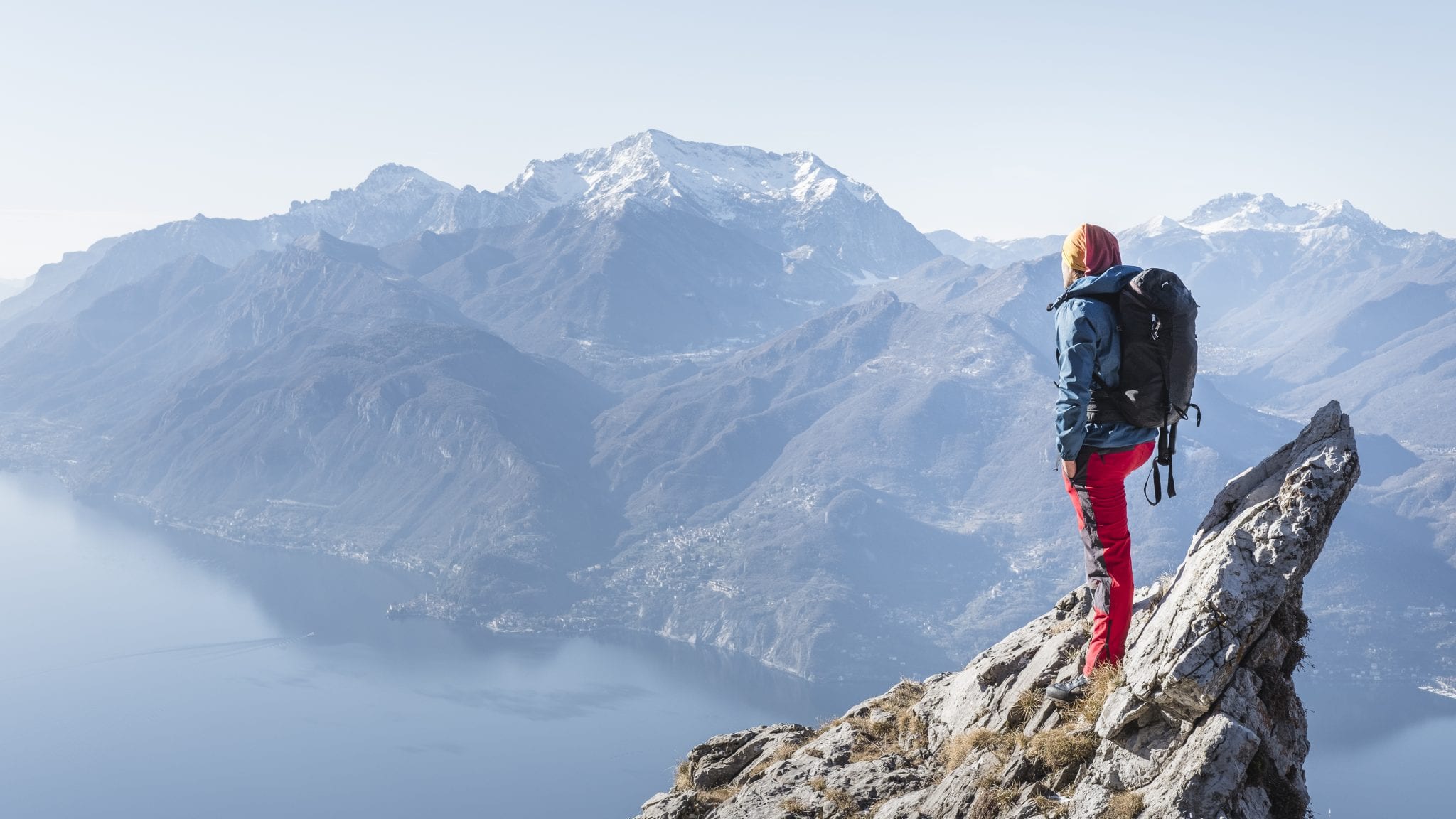 Heidi Zimmer standing at the top of a tall mountain looking out over an expanse of sea and rocky mountains.